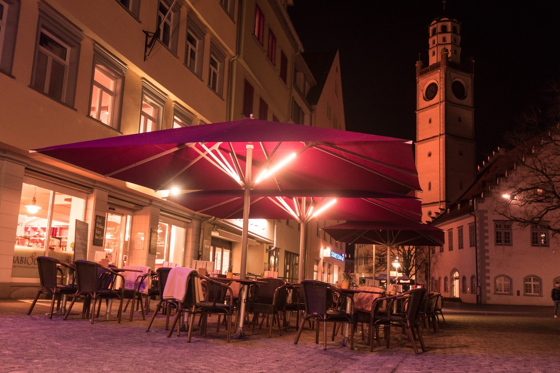 Warmweiße LUME-1 an einem Sonnenschirm im Gastronomiebetrieb