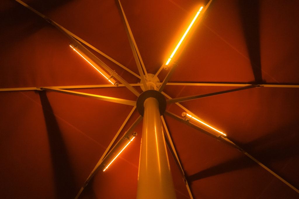 Roter Sonnenschirm mit Oranger LUME-1 Sonnenschirmbeleuchtung